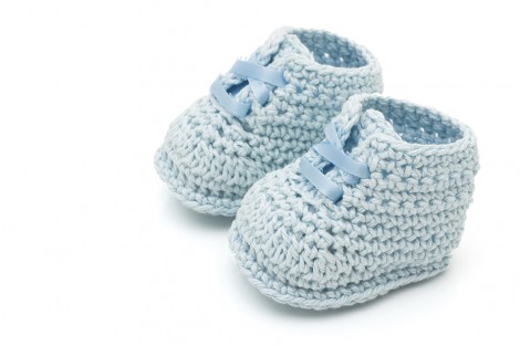Handmade blue baby booties isolated on a white background