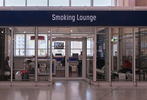 Athens, Greece - May 05, 2015: Smoking lounge at Athens International Airport Eleftherios Venizelos with passengers seating inside in Athens, Greece. Smoking lounge is the only zone where people can smoke inside airport building.