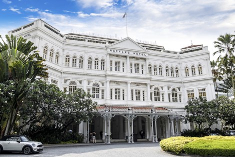 Singapore, Singapore - April 6, 2011: Guests enter the Raffles Hotel in Singapore. The colonial-style hotel is one of the most famous icons of Singapore established in 1899. It was named after the founder of Singapore, Sir Stamford Raffles.