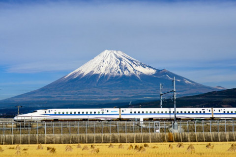 JAPAN - DECEMBER 14, 2012: A Shinkansen bullet train passes below Mt. Fuji in Japan.