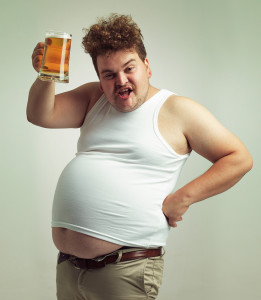 Shot of an overweight man raising his beer in toast