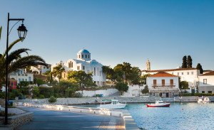 Spetses Town promenade on the Aegean island of Spetses, Greece, showing the old Monastery of Agios Nikolaos which is now the island's cathedral.