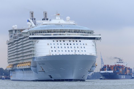 Vlaardingen, Netherlands - October 14, 2014: the MS Oasis of the Seas, the largest cruise ship in the world and owned by Royal Caribbean International, leaving the port of Rotterdam after maintenance service at the Dutch shipyard Keppel Verolme. The ship has a capacity of 6,360 passengers, is 362 meters long, 60 meters wide and 65 meters high. Before leaving Rotterdam the owner had to pay a fine to the Dutch government for violation of rules and regulations.